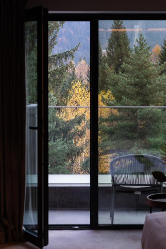 a room with a window with a view of trees at Hotel Simona Halep - Poiana Brasov in Poiana Brasov