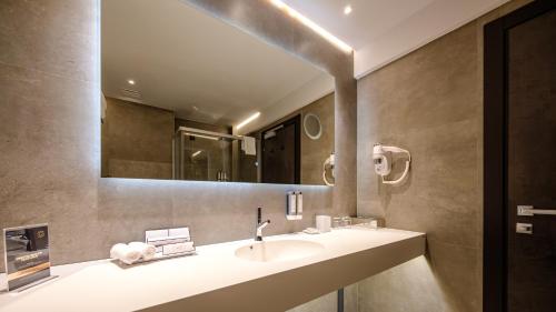 a bathroom with a sink and a mirror at Hotel Simona Halep - Poiana Brasov in Poiana Brasov