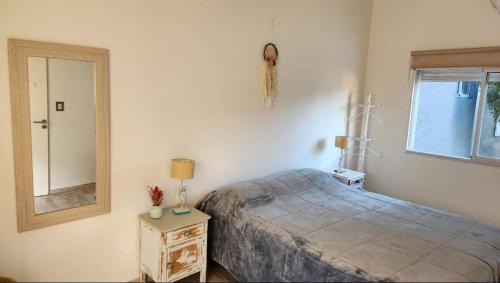 Un dormitorio con una cama y un espejo en la pared. en Casa en Sauce Grande - Calvario, en Balneario Sauce Grande