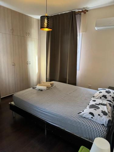 a bedroom with a bed with a black and white comforter at Magic Sea Apartments in Larnaka