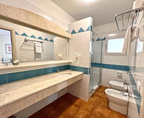 a bathroom with a sink and a toilet and a shower at Apartments In Golfo Orosei in Orosei