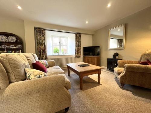 ein Wohnzimmer mit zwei Sofas und einem Couchtisch in der Unterkunft The Byre in Easington