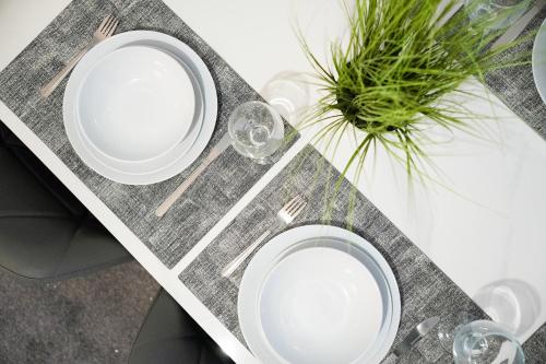 two white plates and glasses on a table at NEW! Spacious 4BR in Sidney in Bishop Auckland