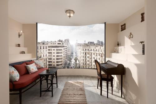 开罗2BR DownTowen Orabi khan prime location in the heart of cairo的客厅里有一张红色的沙发和一扇大窗户