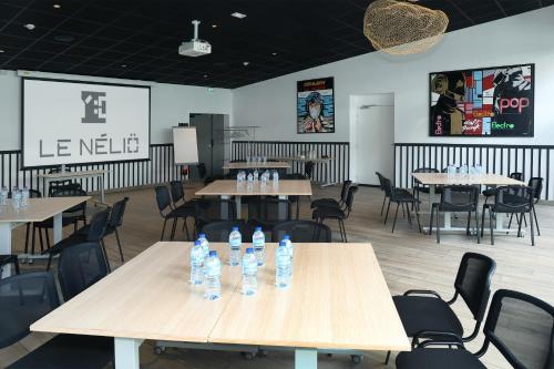 a restaurant with tables and chairs with water bottles on them at Le Néliö in Aix-en-Provence