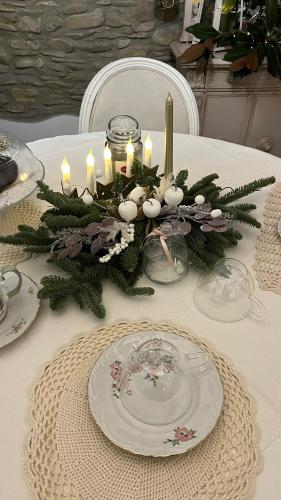 a table with a christmas centerpiece with candles on it at BB Lady in Castelvetro di Modena