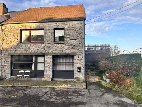 a brick house with two windows and two chairs at Meuse Riverside in Hastière-par-delà