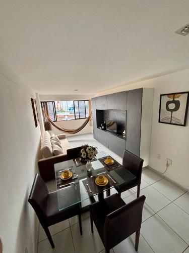 a living room with a table and chairs and a couch at Apartamento Amplo - Ideal para famílias in João Pessoa