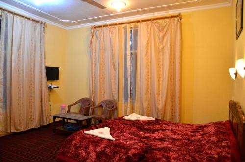 a bedroom with a bed and a table and curtains at Goona residence in Srinagar