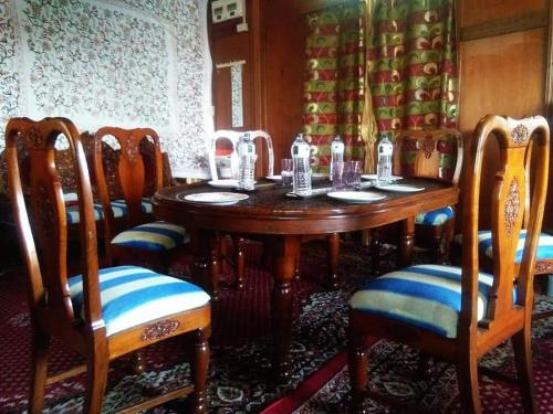 a dining room with a wooden table and chairs at Goona residence in Srinagar
