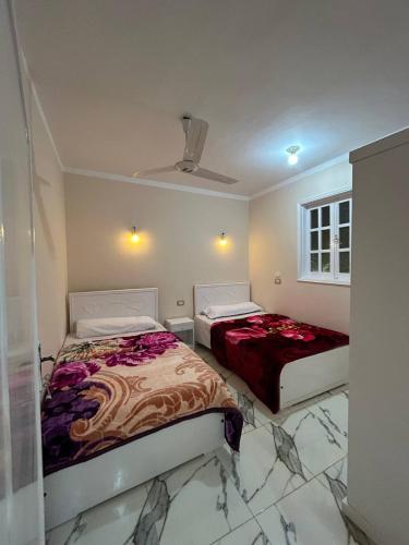 two beds are in a room with at The Nile flat in Luxor