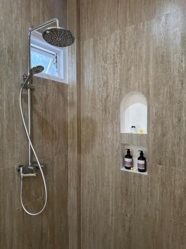 a bathroom with a shower with a shower head at Ellies Hotel in Nusa Dua