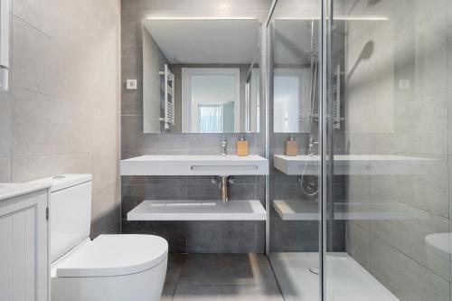 a bathroom with a toilet and a sink and a shower at Hauzify I Apartament Jardins d'Aro in Platja  d'Aro