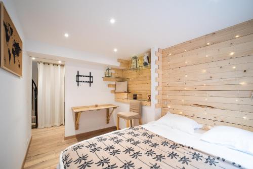 une chambre avec un lit et un mur en bois dans l'établissement Terroir et Mer - A 5min à pied de la plage, à Banyuls-sur-Mer