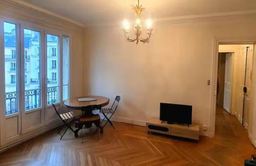 ヌイイ・シュル・セーヌにあるParis Neuilly Défenseのテーブルとテレビのあるダイニングルーム