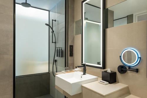 a bathroom with a sink and a mirror and a shower at Sheraton Mall of the Emirates Hotel, Dubai in Dubai