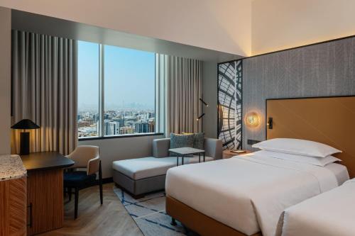 a hotel room with a bed and a desk and a window at Sheraton Mall of the Emirates Hotel, Dubai in Dubai