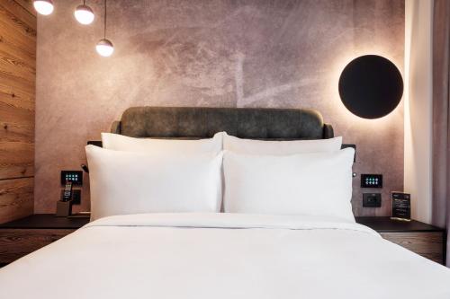 a bed with white pillows in a bedroom at Hotel Simona Halep - Poiana Brasov in Poiana Brasov