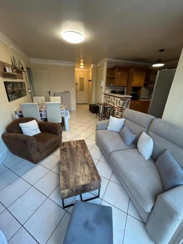 un salon avec deux canapés et une table dans l'établissement Chez Jojo, 250m de la plage, wifi & climatisation, à Canet