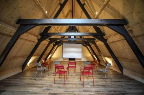 a room with red chairs and a white screen in a attic at Ô Chiroulet - Le Refuge de l'Isard in Bagnères-de-Bigorre