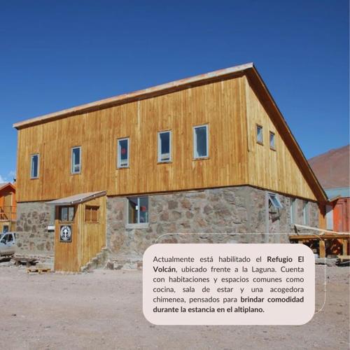 a large wooden building with a sign in front of it at Refugio El Volcán in Angostura