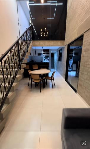 a hallway with tables and chairs and a staircase at Loft Adélia in Triunfo