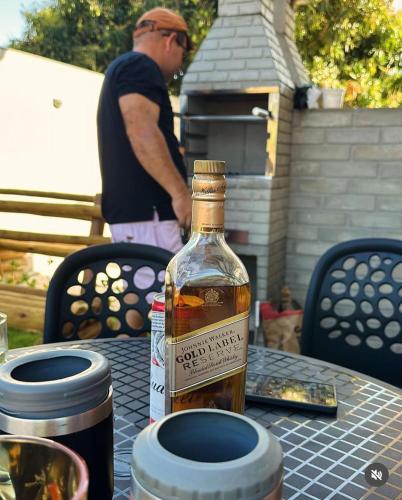 a bottle of whiskey on a table with a man in the background at Loft Adélia in Triunfo
