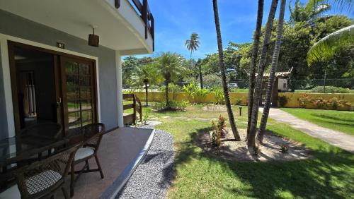 une terrasse couverte d'une maison avec un palmier dans l'établissement Casa Lírio - Beira da praia, à Porto Seguro