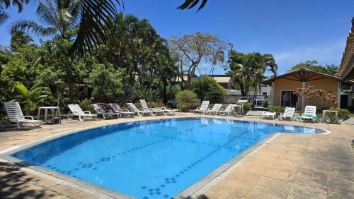 une grande piscine avec des chaises longues dans l'établissement Casa Lírio - Beira da praia, à Porto Seguro