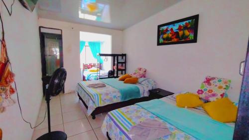 a bedroom with two beds and a tv on the wall at Casa Campestre San Joaquin in Restrepo