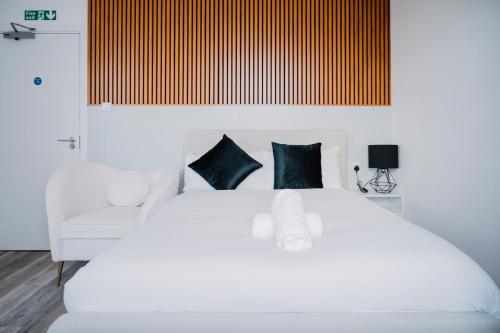 a bedroom with a white bed with blue pillows at WNS Skylines Village in London