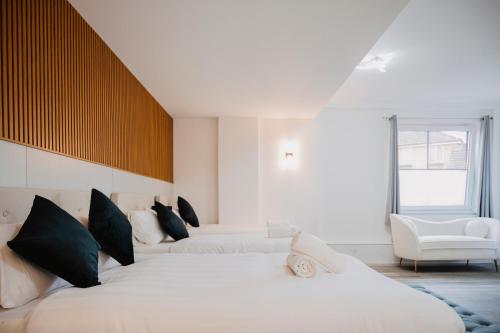 a bedroom with two beds and a chair at WNS Skylines Village in London