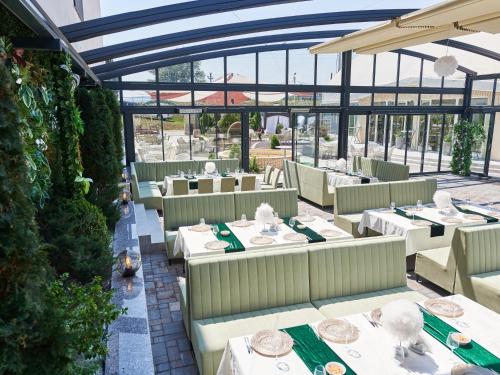 an empty restaurant with white tables and chairs at Hotel EMD in Bacău