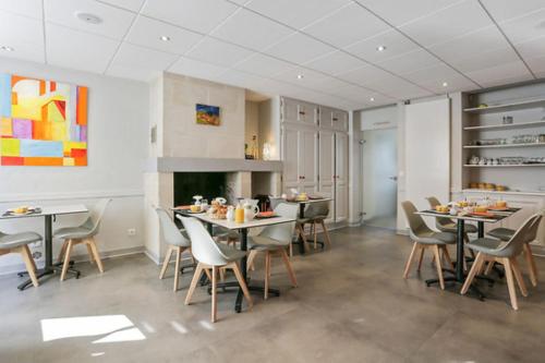 a dining room with tables and chairs at Logis Hôtel Le Pélican & son restaurant in Vernantes