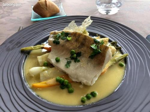 a plate of food with meat and vegetables on a table at Logis Hôtel Le Pélican & son restaurant in Vernantes