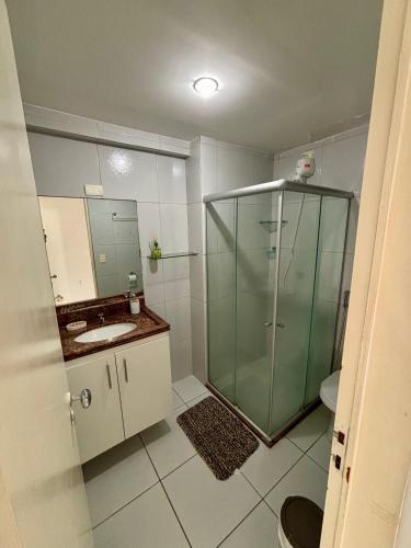 a bathroom with a glass shower and a sink at Apartamento Amplo - Ideal para famílias in João Pessoa