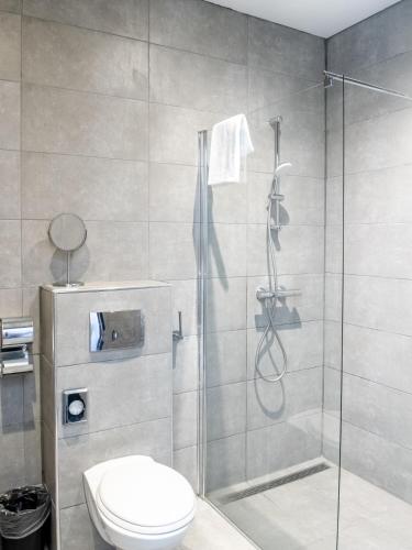 a bathroom with a shower and a toilet at Amsterdam Lake Hotel in Badhoevedorp
