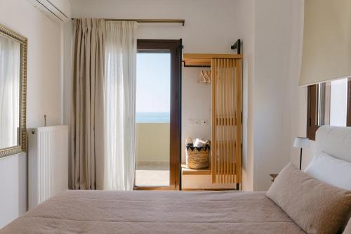 a bedroom with a bed and a view of the ocean at Greco Levantes Villas in Triopetra