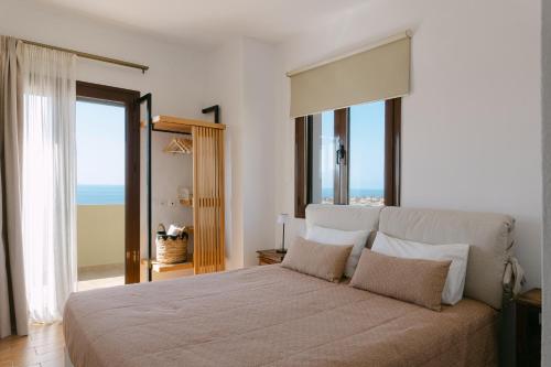 a bedroom with a large bed with a view of the ocean at Greco Levantes Villas in Triopetra