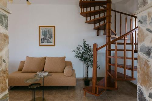 a living room with a couch and a spiral staircase at Greco Levantes Villas in Triopetra