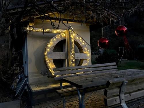 a wooden bench with a circle of lights around it at Hotel Neuhausmühle in Vilpiano