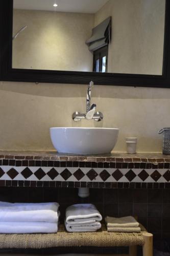 a bathroom with a sink and a mirror and towels at Villa Quince in Ouirgane