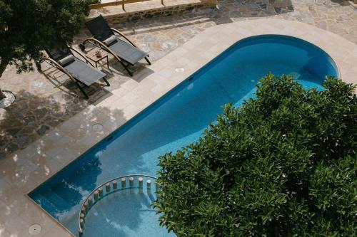 an overhead view of a blue swimming pool with chairs at Greco Levantes Villas in Triopetra