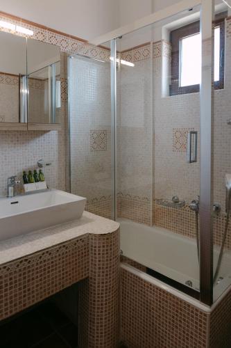 a bathroom with a sink and a shower and a tub at Greco Levantes Villas in Triopetra