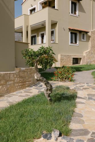 a small tree in the grass in front of a building at Greco Levantes Villas in Triopetra