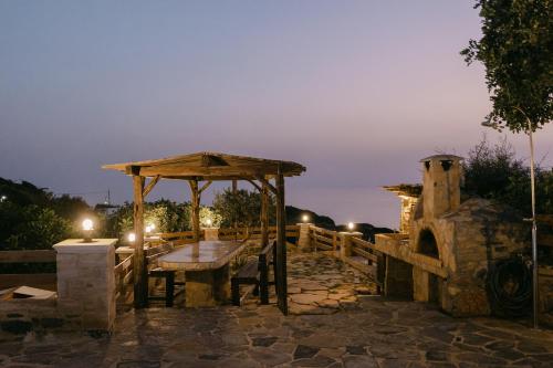 a stone patio with a table and a gazebo at night at Greco Levantes Villas in Triopetra