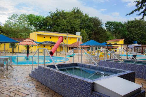 a pool with a slide in the middle of it at Hotel Fazenda Pé da Serra in Bom Sucesso