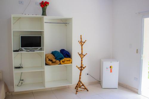 a white room with a tv and a refrigerator at Hotel Fazenda Pé da Serra in Bom Sucesso