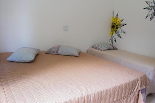 a bedroom with two beds and a sunflower on the wall at Hotel Fazenda Pé da Serra in Bom Sucesso