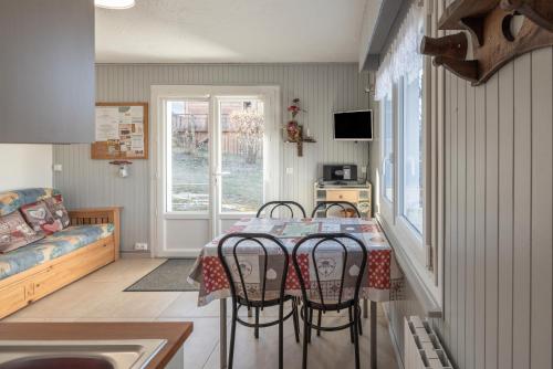 une salle à manger avec une table et quatre chaises dans l'établissement Les Rocailles, à Notre-Dame-de-Bellecombe
